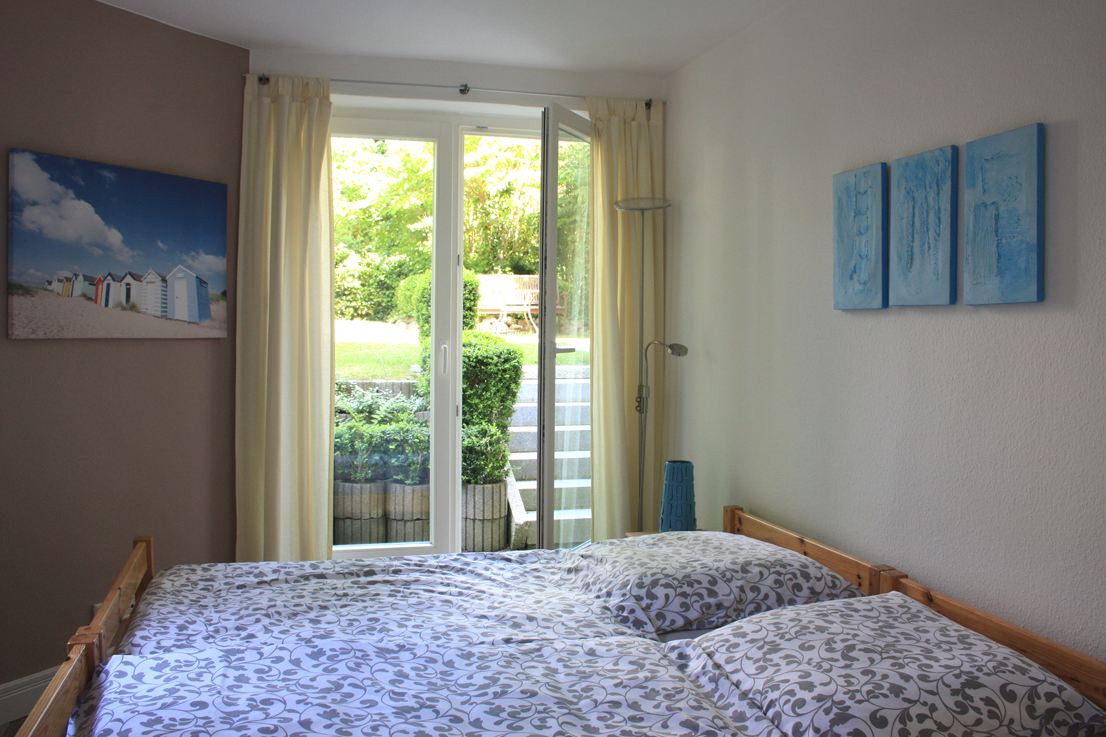 Schlafkabine mit Doppelbett und Tür zum Garten